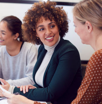 Young professional woman talking to another woman in a business meeting